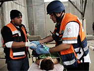 Injured Palestinian receiving medical treatment by Israeli and Palestinian medical personnel at the crossing