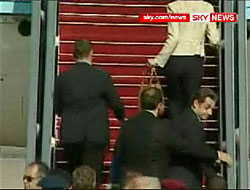 Nicolas Sarkozy rushed by security officers onto the presidential plane