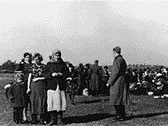Jewish women and children who have already surrendered their belongings form a small group as others in the background are ordered to discard their outer clothing and their possessions prior to execution. Photograph was taken October 16, 1941 in Lubny, the Ukraine
