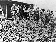 Soviet soldiers investigating Majdanek survey a warehouse containing thousands of shoes confiscated from murdered prisoners