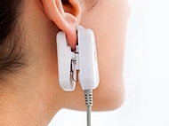GlucoTrack users test glucose levels with an ear clip attached to a handheld control unit. Photo: courtesy